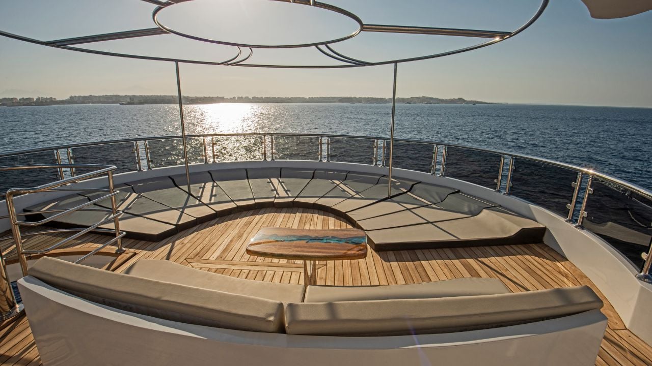 Teak stern deck of a luxury motor yacht with sunbeds and tropical sea view