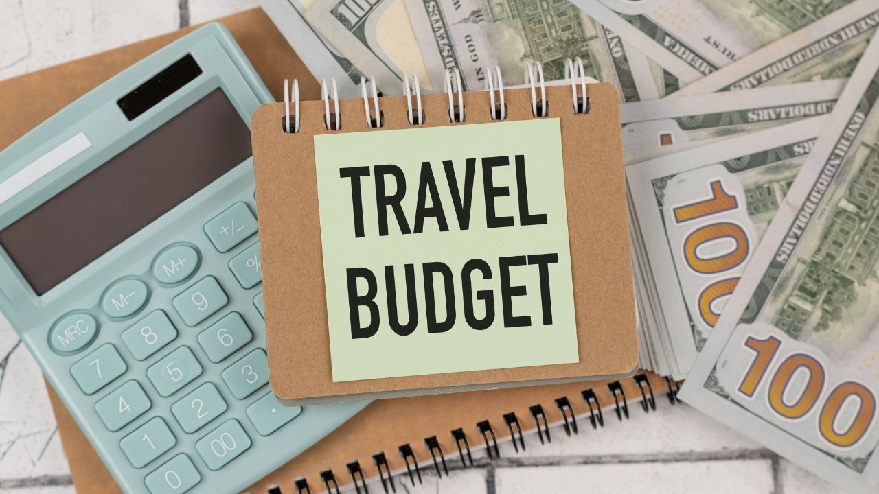 Travel budget text on blue background with airplane figurine and seashells