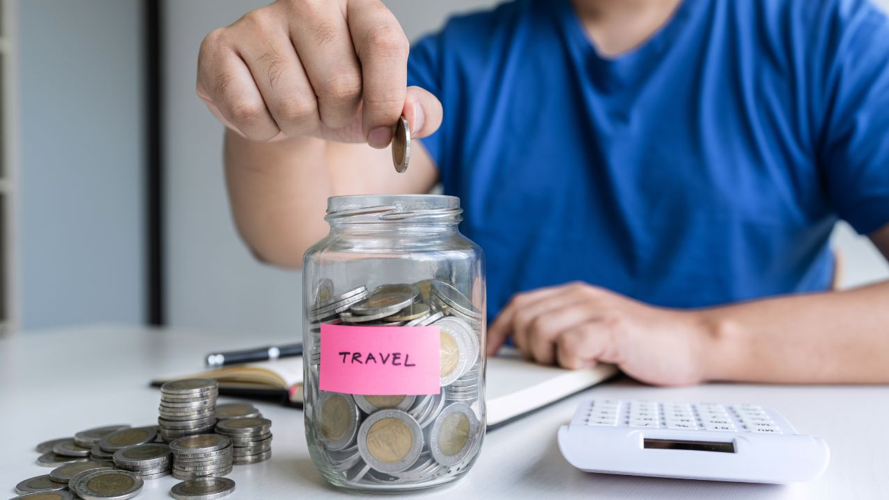 Man putting coins aside for future travel savings