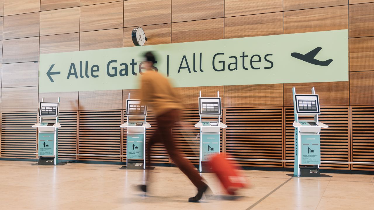 Woman running with suitcase toward airport gate