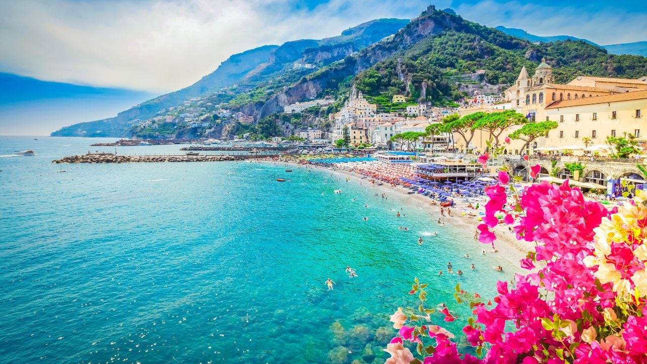 Amalfi town and summer beach with clean blue water and flowers , Italy