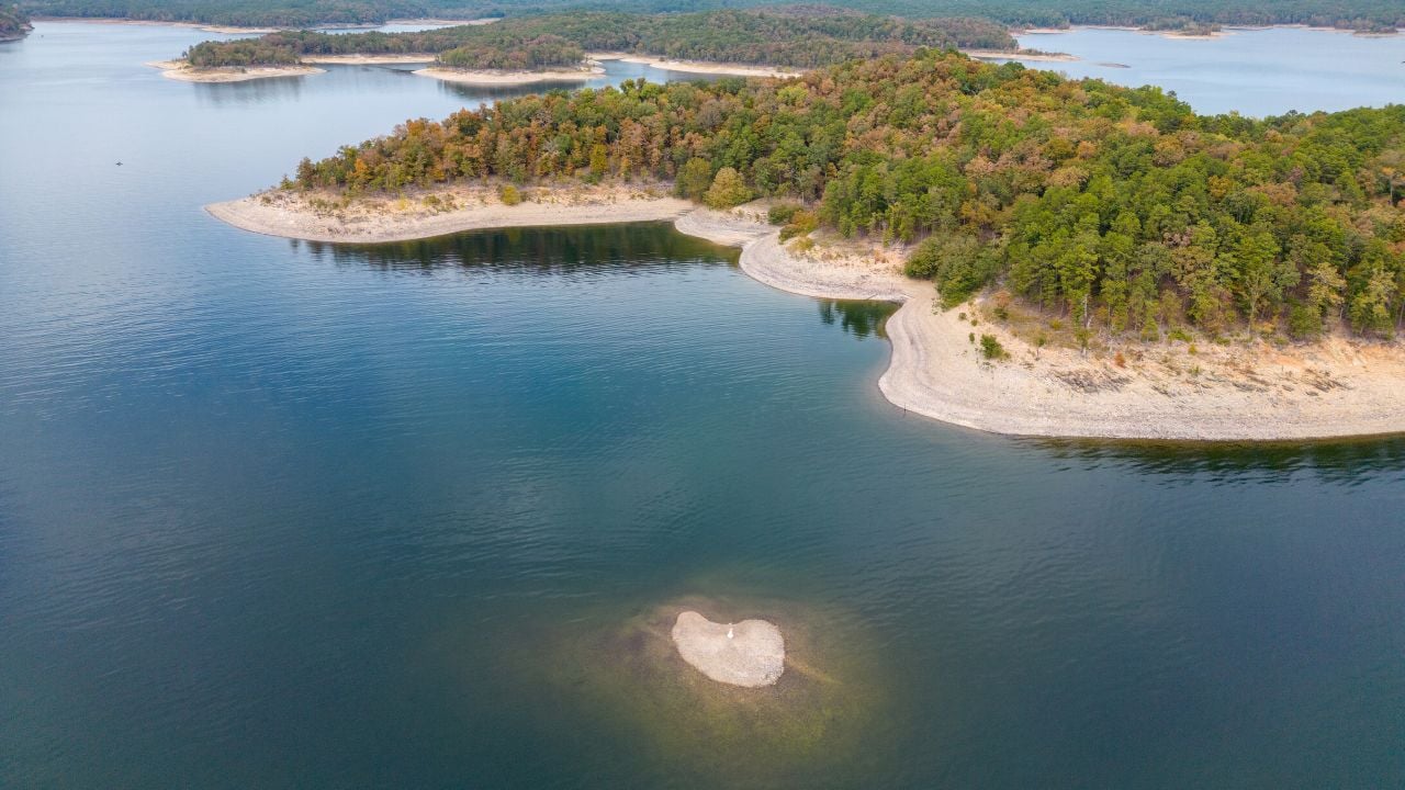 Aerial view of landscape of water of Broken Bow lake and islands with forest on the bank, Oklahoma, USA. Autumn scenery of coastal line.