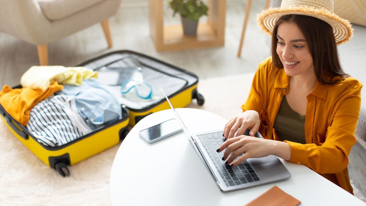 Traveler booking a hotel online with a laptop at home