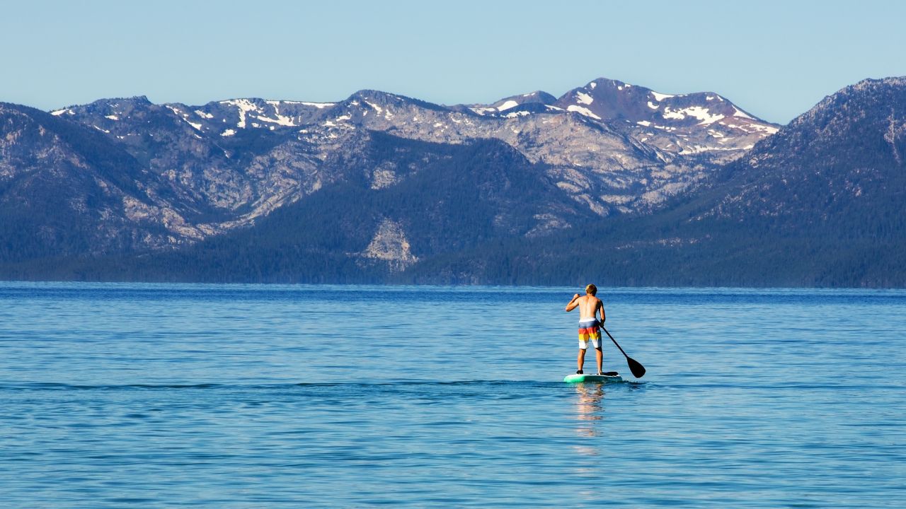 Paddleboarder on Lake Tahoe at sunrise.