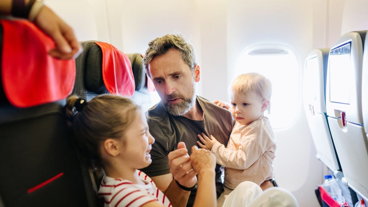 Father calming an upset child during a flight.