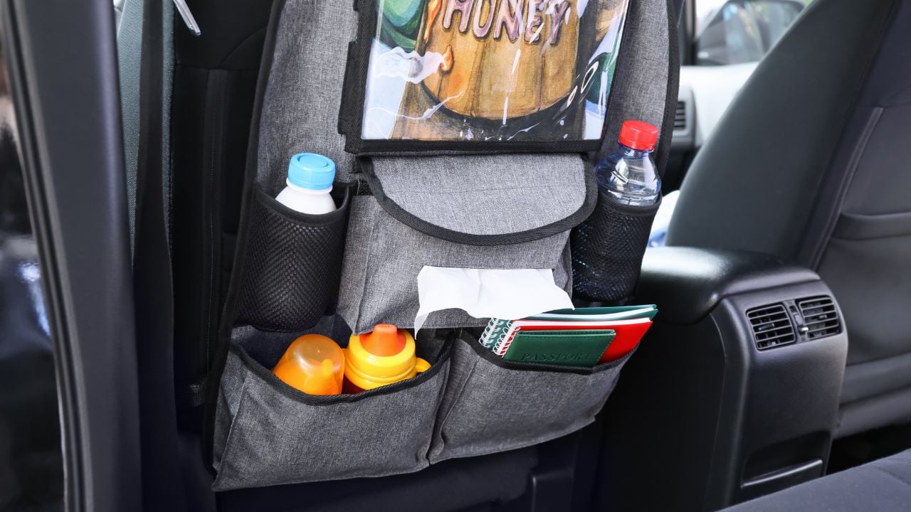 Travel organizer with different things on a car seat.