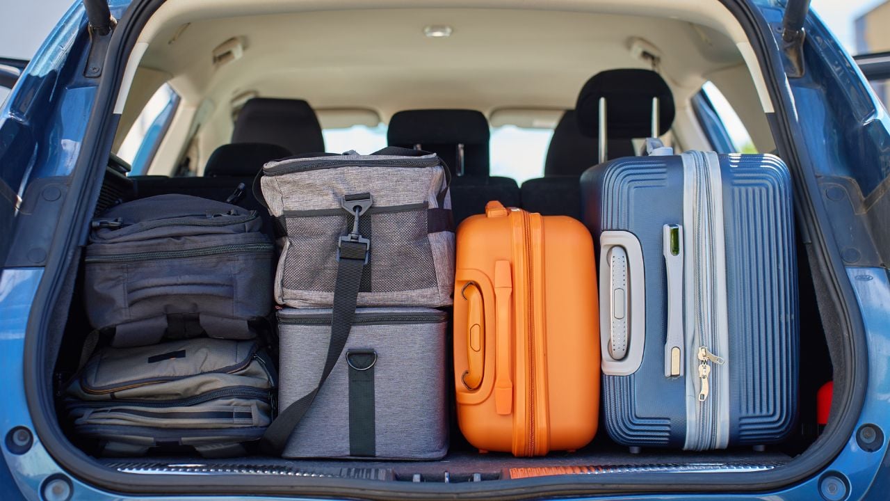 Car trunk packed with suitcases, backpacks, and bags.
