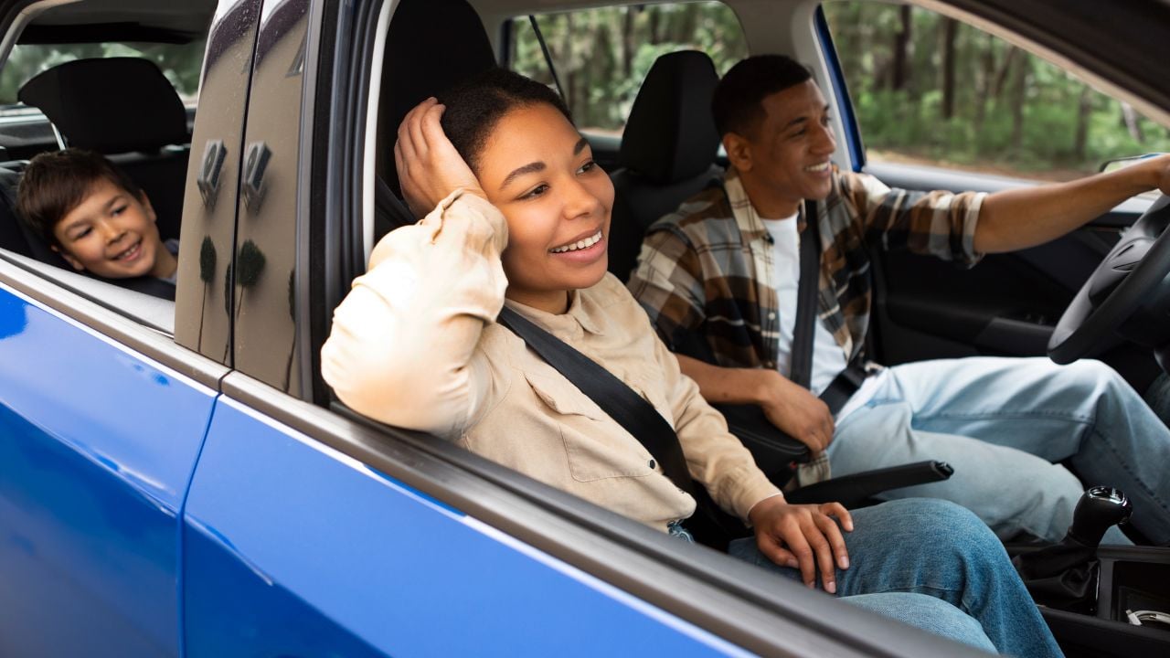 Happy woman and child boy enjoying family trip by car, looking through windows. People enjoy weekend, vacation at new auto and life insurance