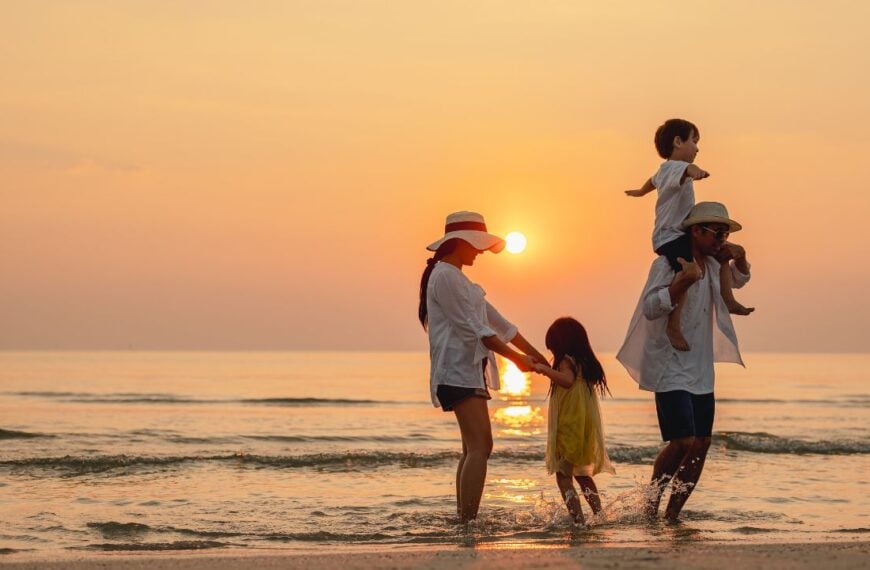 Happy asian family that enjoys beach activities during the summer holidays. parent and children enjoy the sunset sea on beach.Holiday travel concept, Summer vacations.