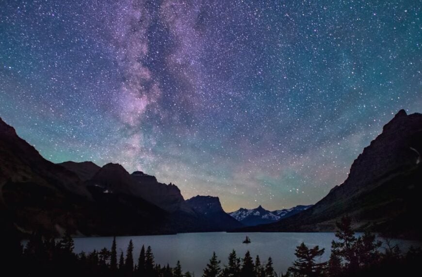 The Milky Way stretches across a clear night sky above a quiet mountain lake, capturing the kind of darkness and clarity that make U.S. dark sky parks so memorable for stargazing.