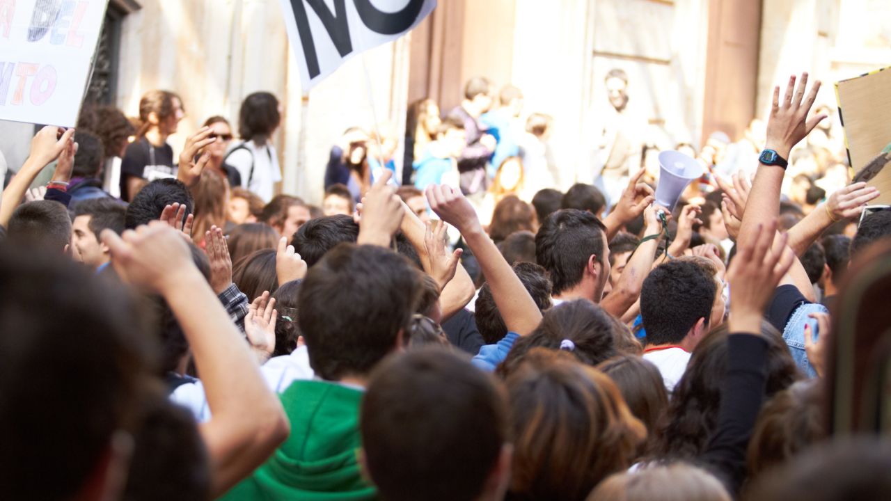 Crowd protesting outside a public building.