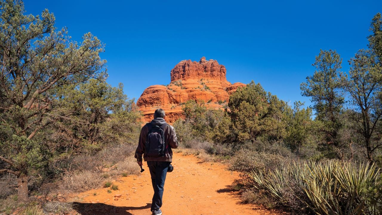 Man on spring hiking trip in Sedona. Hiker walking on Bell Rock Loop and Courthouse Buttle loop Trai.Bell Rock is one of Sedona's most known Vortex Meditation sites.Just south of Sedona, Arizona,USA.