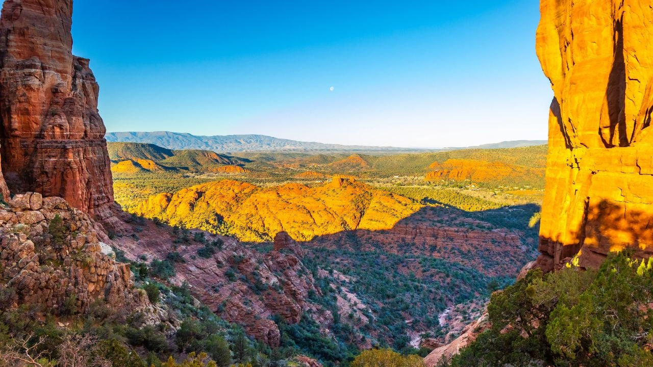 Sunrise view over Sedona from Cathedral Rock with red sandstone landscape and valley below