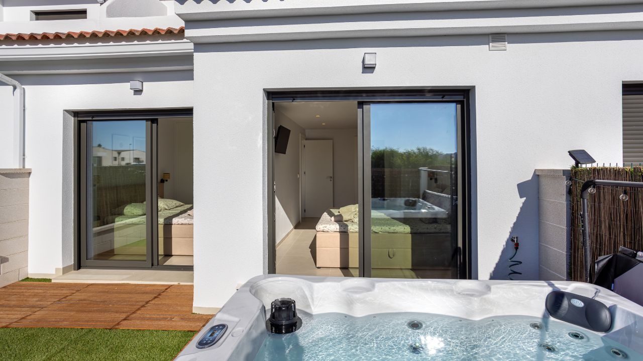 Torrevieja Spain 24 September 2025: Two cozy bedrooms with sliding glass doors opening to a private outdoor hot tub area.