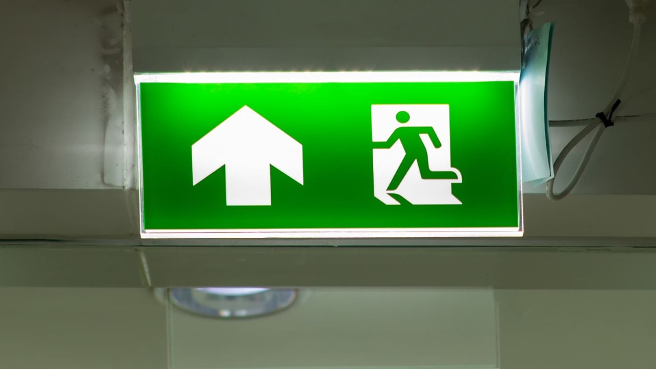 Green emergency exit sign showing a fire escape route