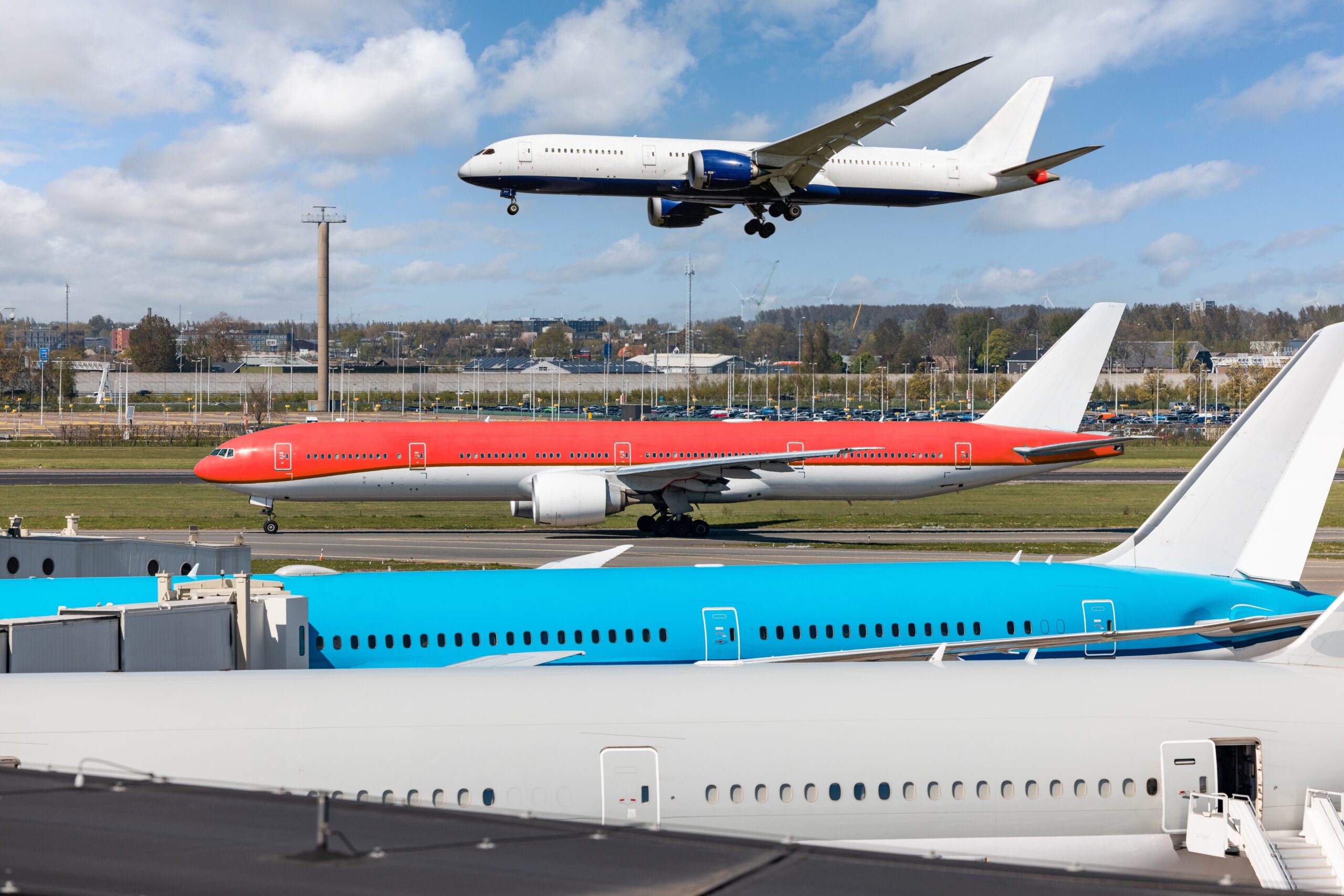 Busy airport with multiple airplanes at gates and on the runway