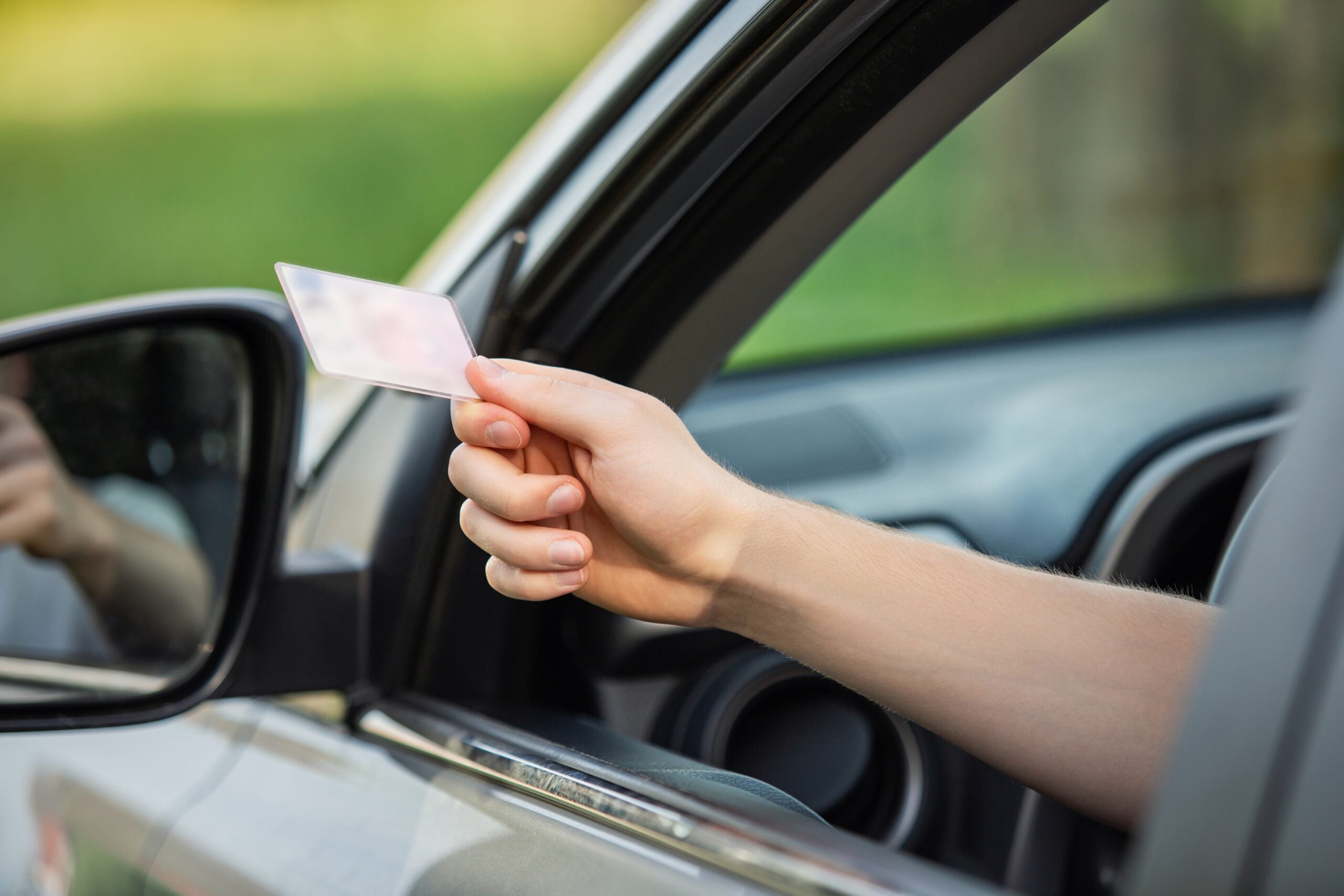 man giving drivers license in car