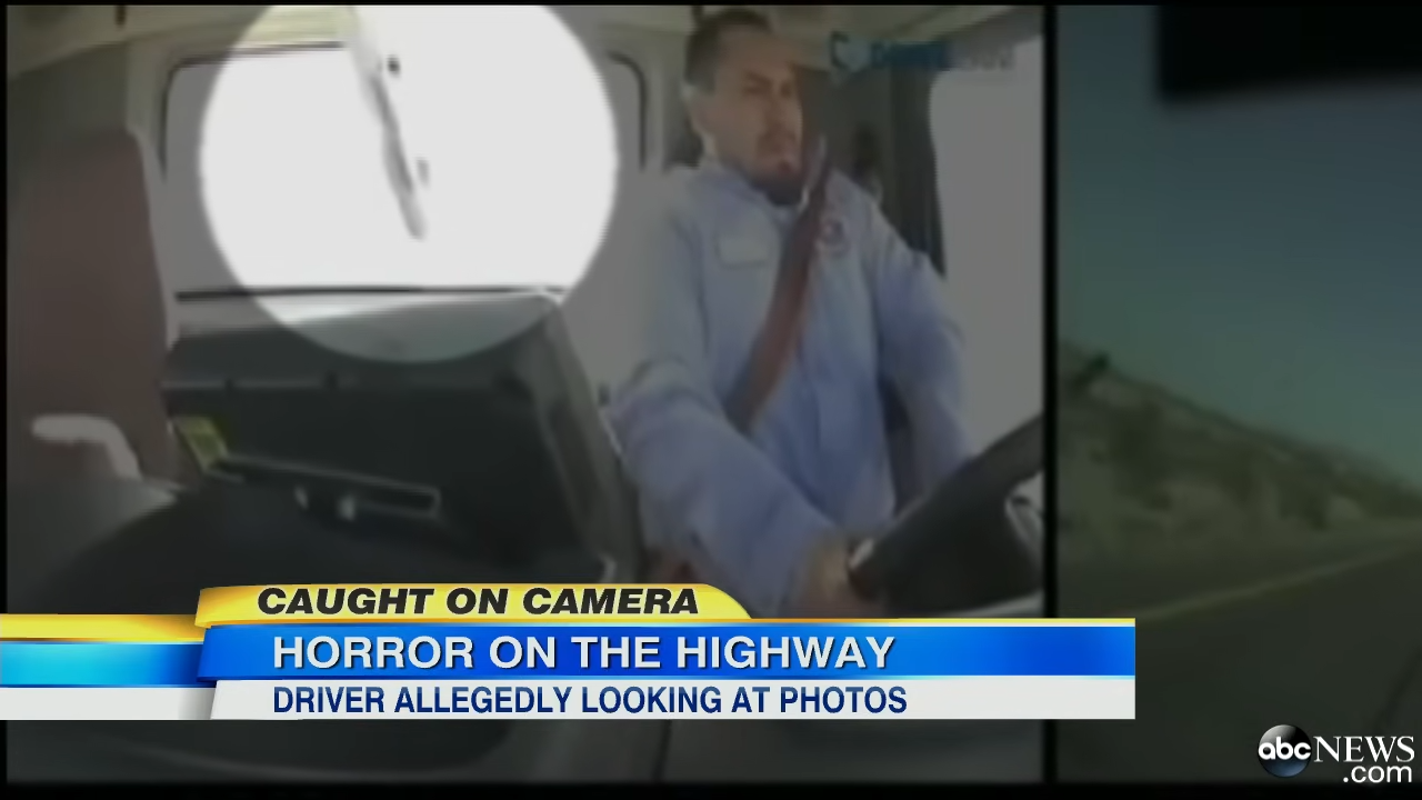 trucker looking at phone hits car