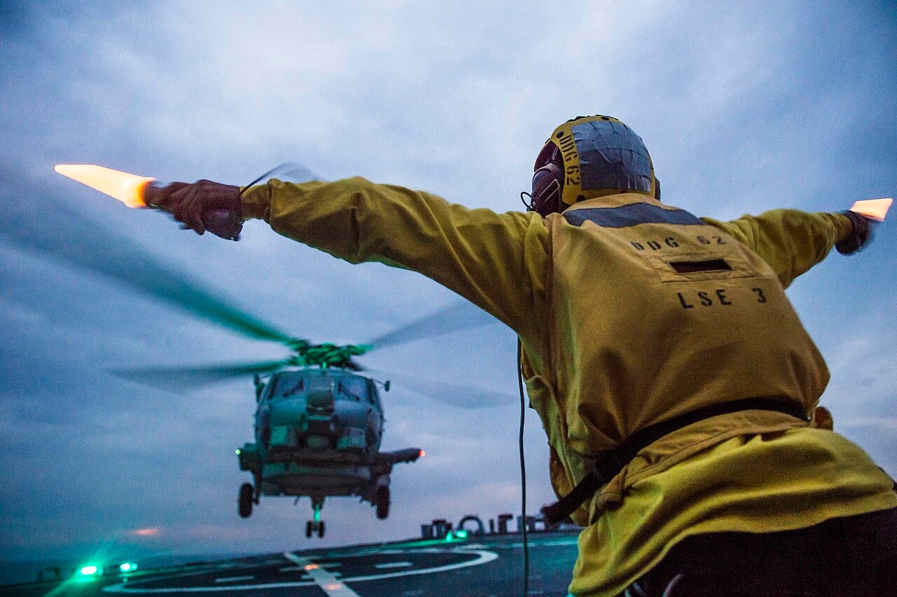 Boatswain’s Mate 2nd Class Febris Soto, from New York City, signals to the pilot of a MH-60 Seahawk of Helicopter Maritime Strike Squadron (HSM) 51 as it launches from the flight deck of the Arleigh Burke-class guided-missile destroyer USS Fitzgerald (DDG 62). Fitzgerald is on patrol in the U.S. 7th Fleet area of responsibility supporting security and stability in the Indo-Asia-Pacific region.