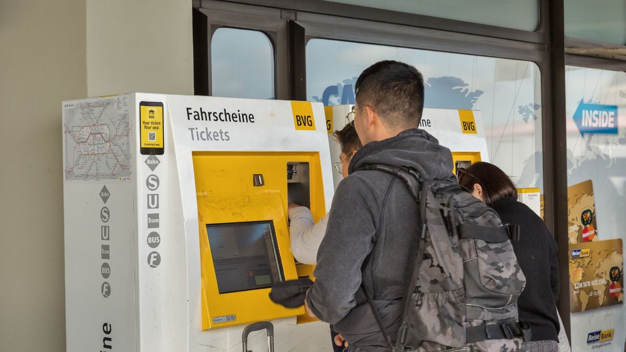Passengers buying public transport tickets at a machine in Berlin, Germany