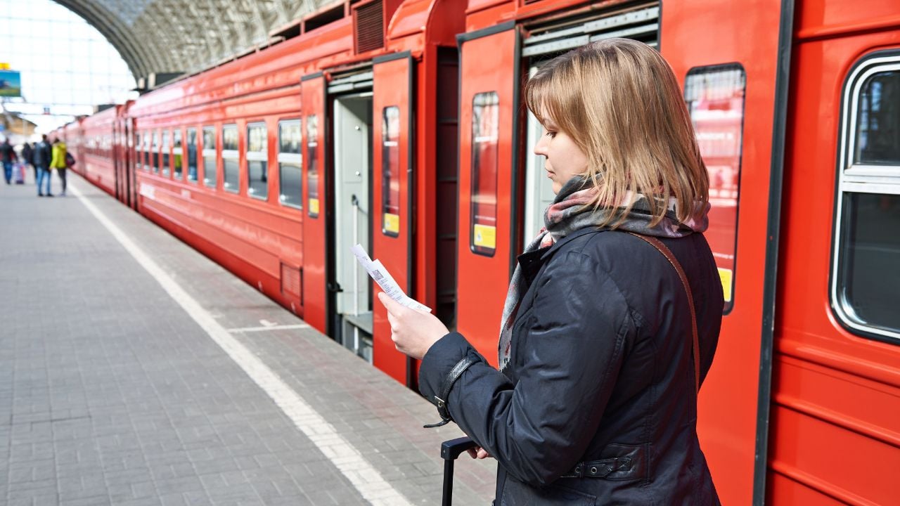 Woman checking her train ticket near a station platform