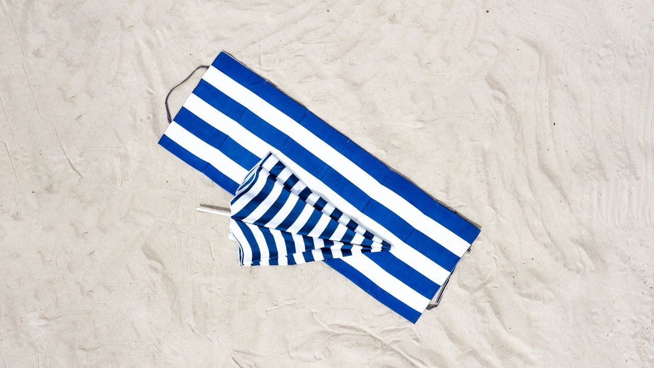 Aerial view of beach umbrellas and towels on the sand
