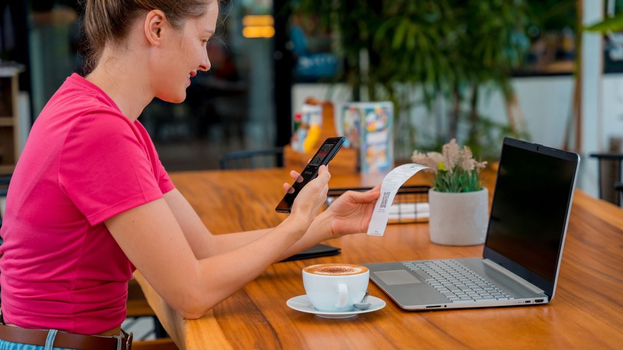 Woman paying by phone at a café