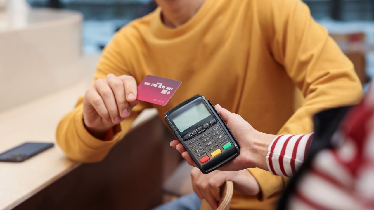 Person paying by credit card at a café terminal