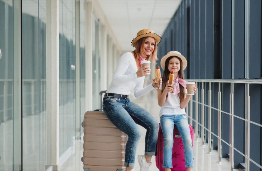 Mom and her daughter are waiting for a vacation waiting for a plane at the airport terminal with luggage. Waiting for airplane mom with daughter eating fast food