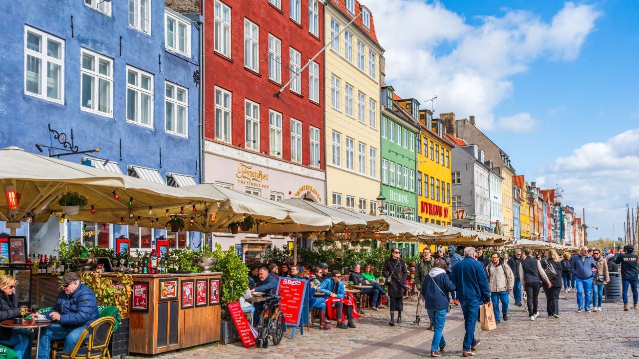 Nyhavn in Copenhagen, Denmark, with colorful facades, cafés, and restaurants along the canal