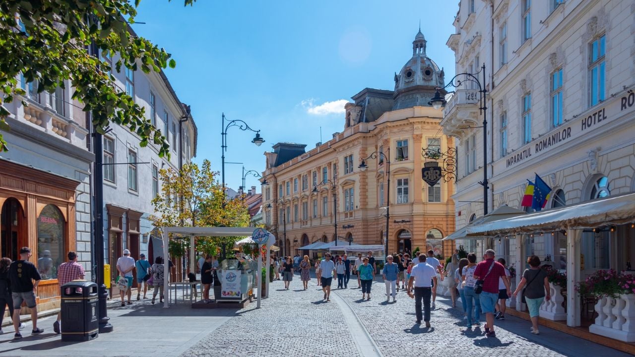 People enjoying a sunny day on a street in Sibiu, Romania