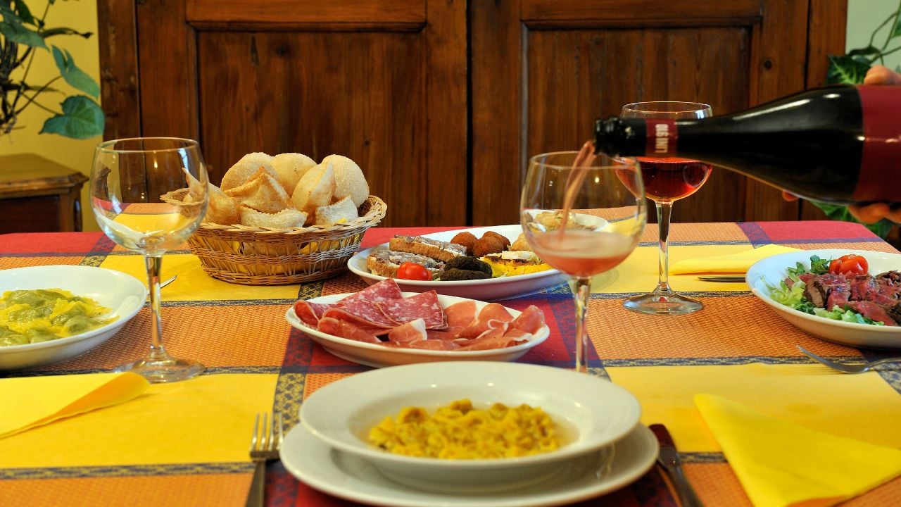 Typical Emilia-Romagna table with Lambrusco, cappelletti, tortelli, cured meats, and regional dishes