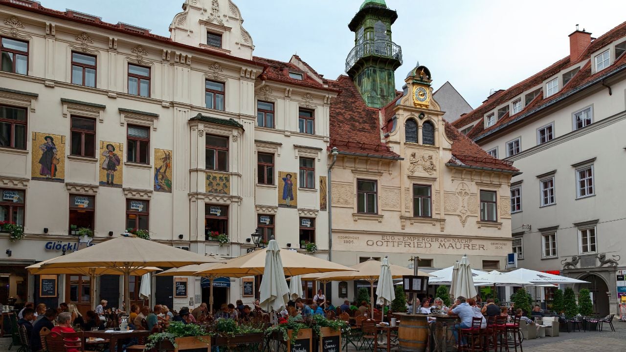 People eating and drinking at an outdoor restaurant in the old town of Graz, Austria