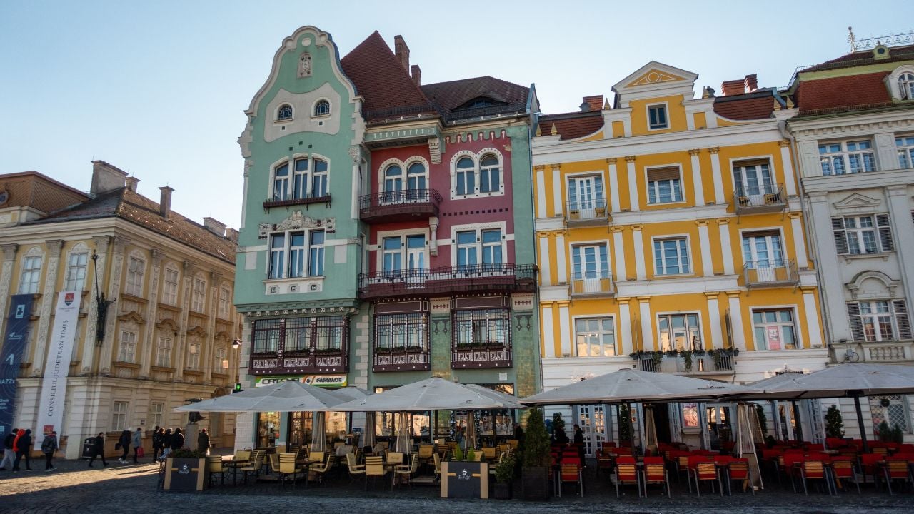 Union Square in Timișoara, Romania, with colorful Baroque buildings and café terraces