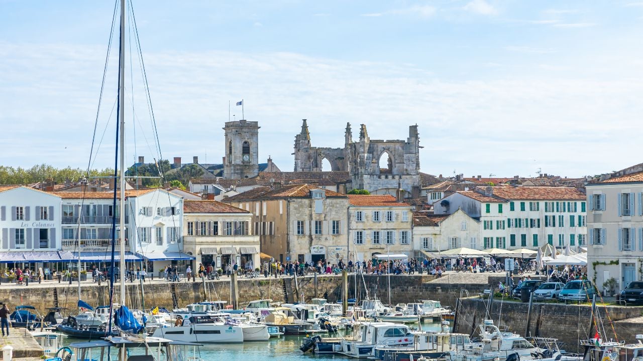 Saint-Martin-de-Ré, France - June 2, 2023 : Quays and towers of the church of Saint-Martin-de-Ré, France with many tourists