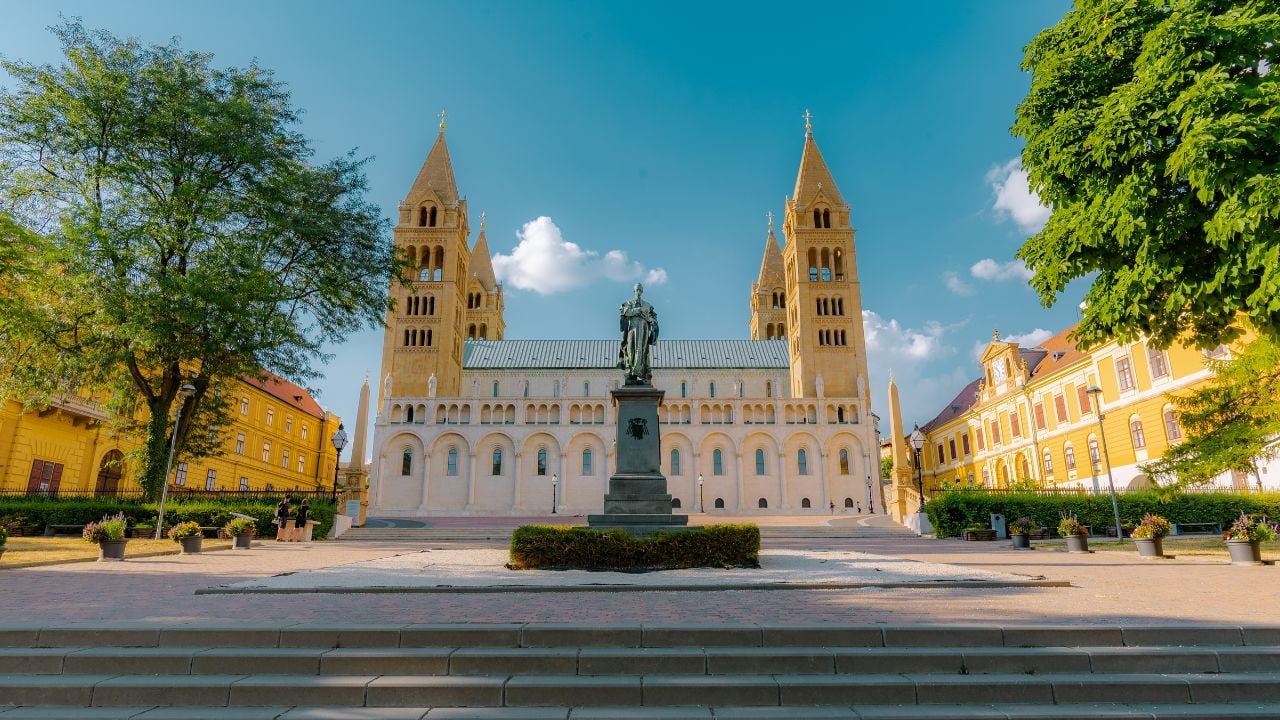 Pécs city center in spring with flowers, trees, and a church