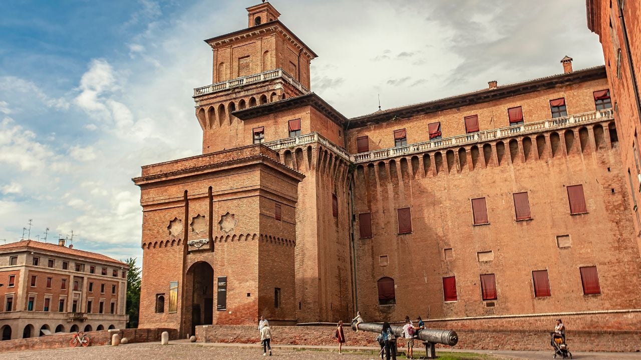 Ferrara, Italy 2 January 2025: Tourists admiring the majestic castello estense in ferrara, a medieval castle with a rich history, under a beautiful cloudy sky