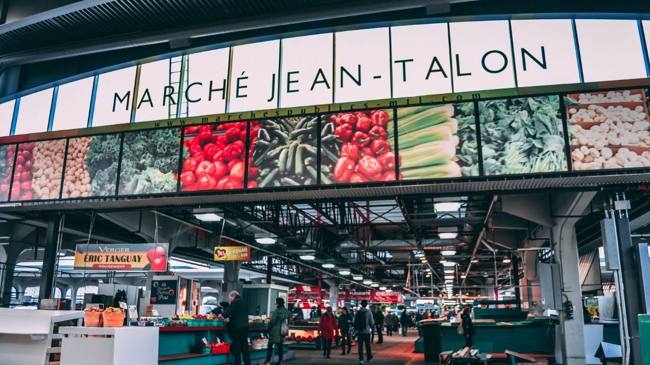 Jean-Talon Market entrance in Montreal with people shopping for produce