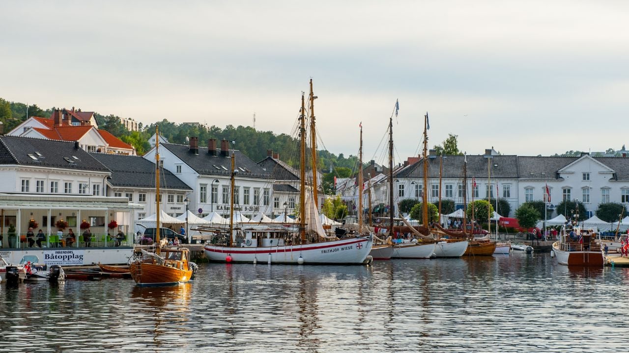 Risør, Norway - August 04 2010: Seaside town with moored boats and historic buildings