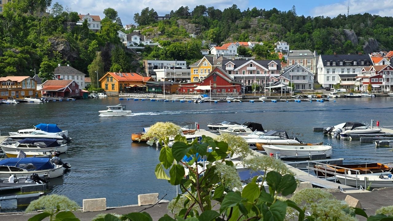 the small town of Kragerø in southern Norway(Scandinavia 16.06.2025), taken from a small foreland, overlooking the harbour of the colorful houses of the city, with Forest, blue sky and white clouds