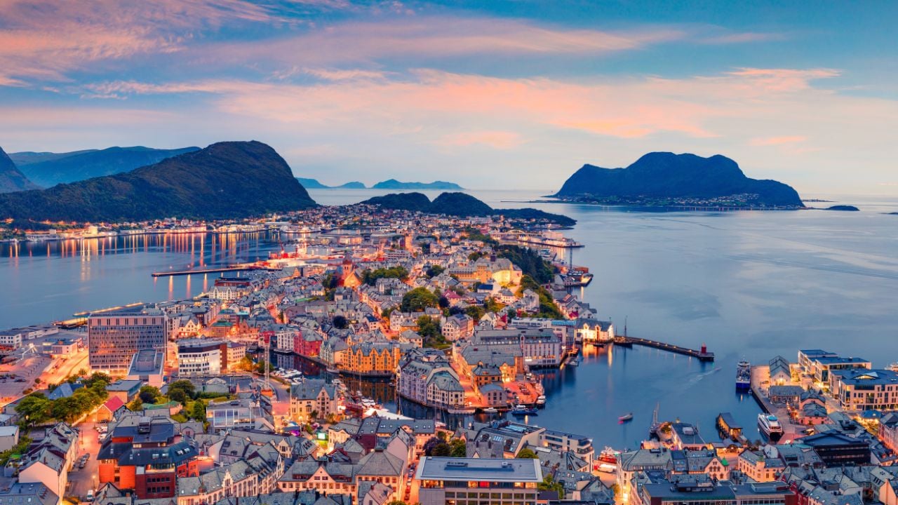 From the bird's eye view of Alesund port town on the west coast of Norway, at the entrance to the Geirangerfjord. Colorful sunset in the North. Traveling concept background.