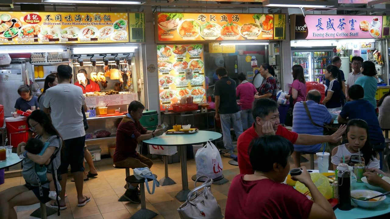 People eating at a hawker center in Chinatown, Singapore