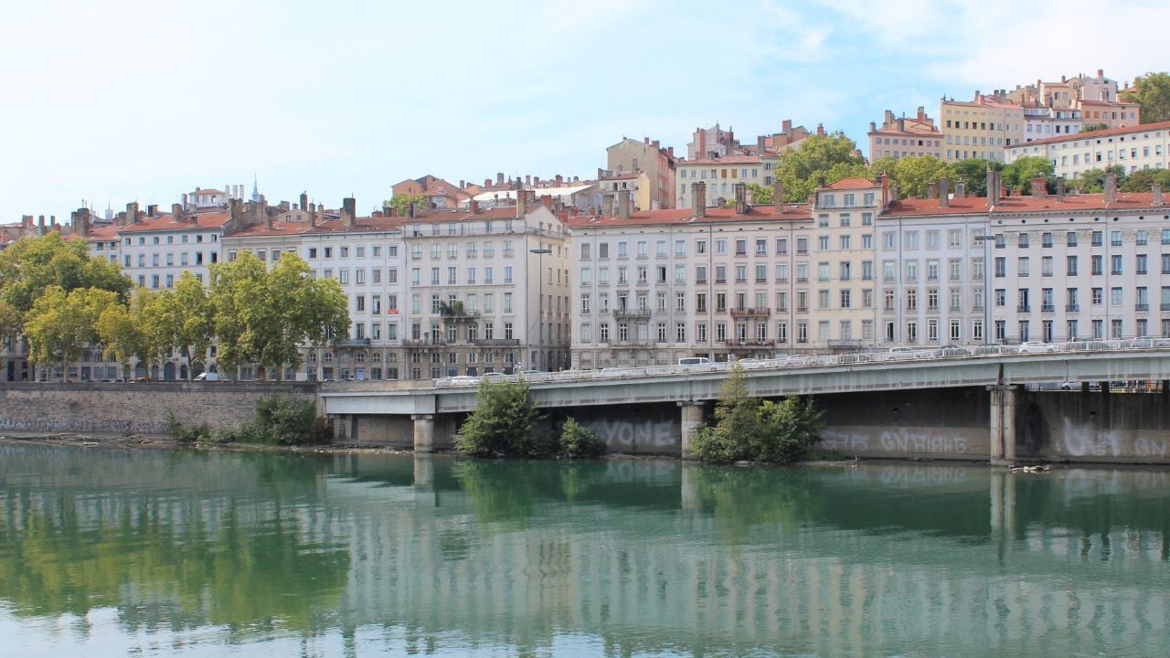Historic Lyon cityscape with riverfront buildings and hillside views.