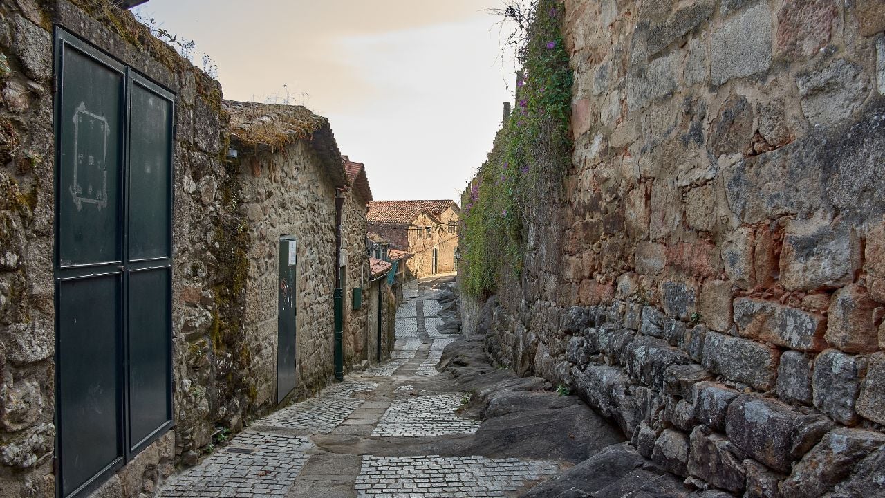 Historic stone street in Galicia with old buildings, stone walls, windows, and wooden doors