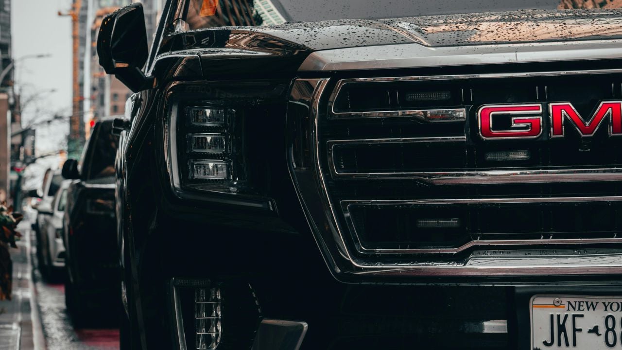 Black GMC vehicle parked on rainy New York City streets