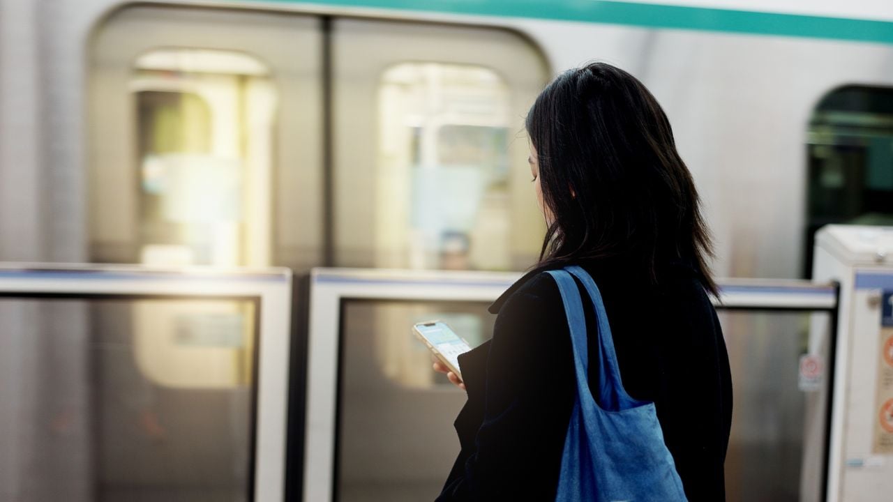 Traveler using a smartphone on public transport.