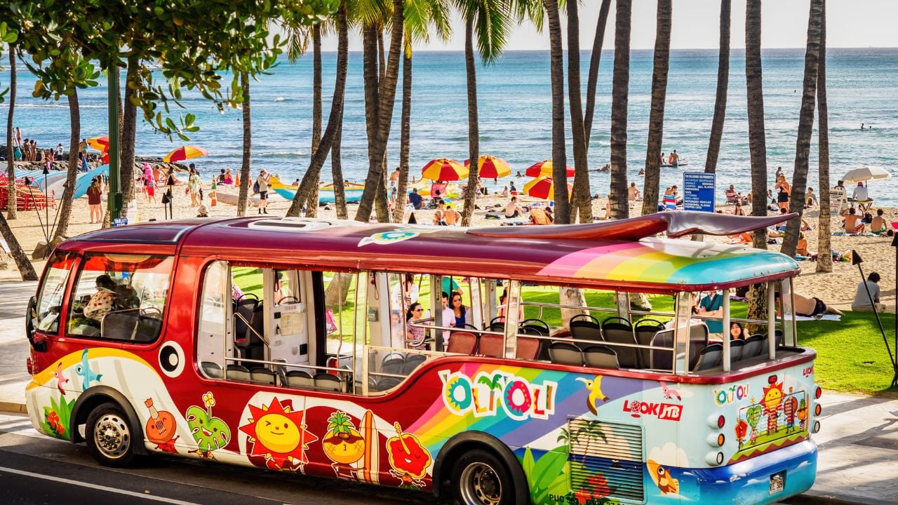 Tourist shuttle bus on Kalakaua Avenue near Waikiki Beach in Honolulu.