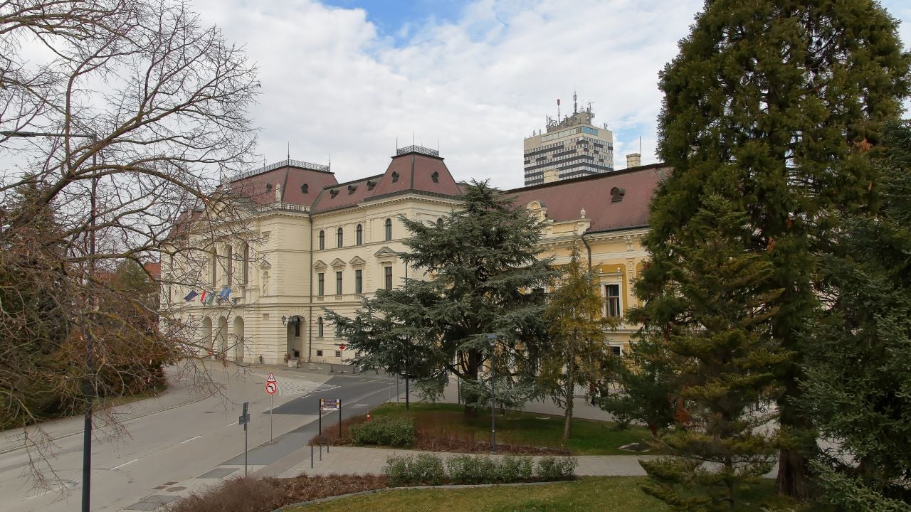 Elegant building facade framed by trees in Veszprém, Hungary.