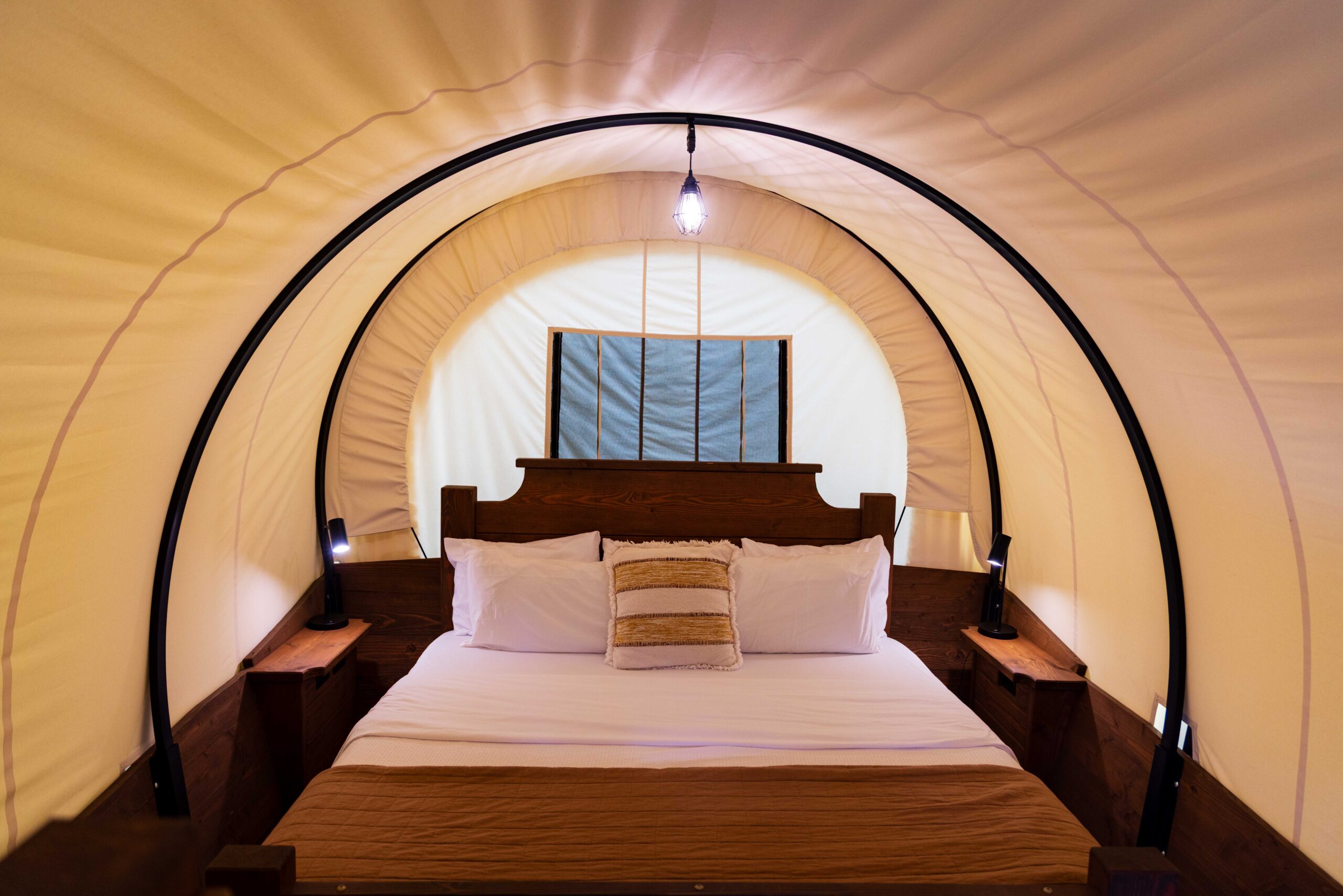 an inside of a covered wagon turned into a bed and place to sleep