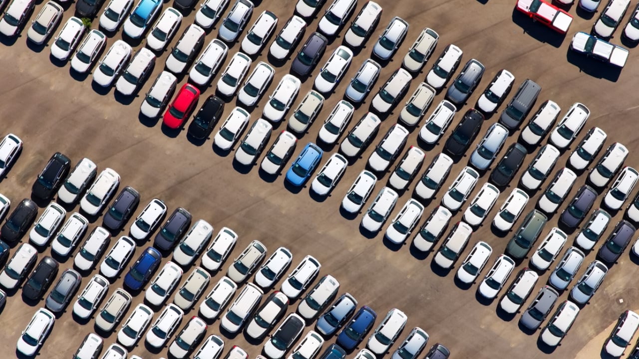 New cars parked on large outdoor storage lot